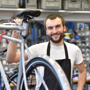 Mann an Fahrrad als Monteur
